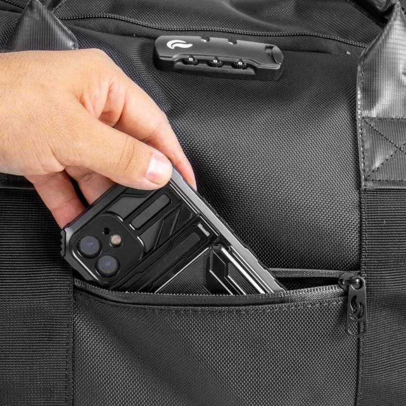 Hand placing phone in front zippered pocket of black travel weekender bag with lock