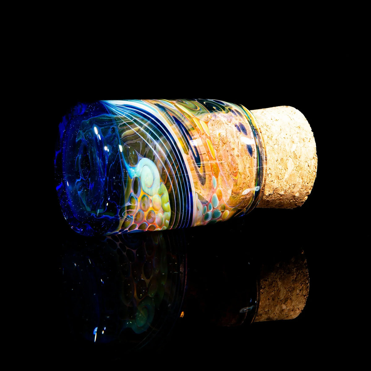 Colorful cobalt fumed glass jar with cork lid, artistic nug container on black background