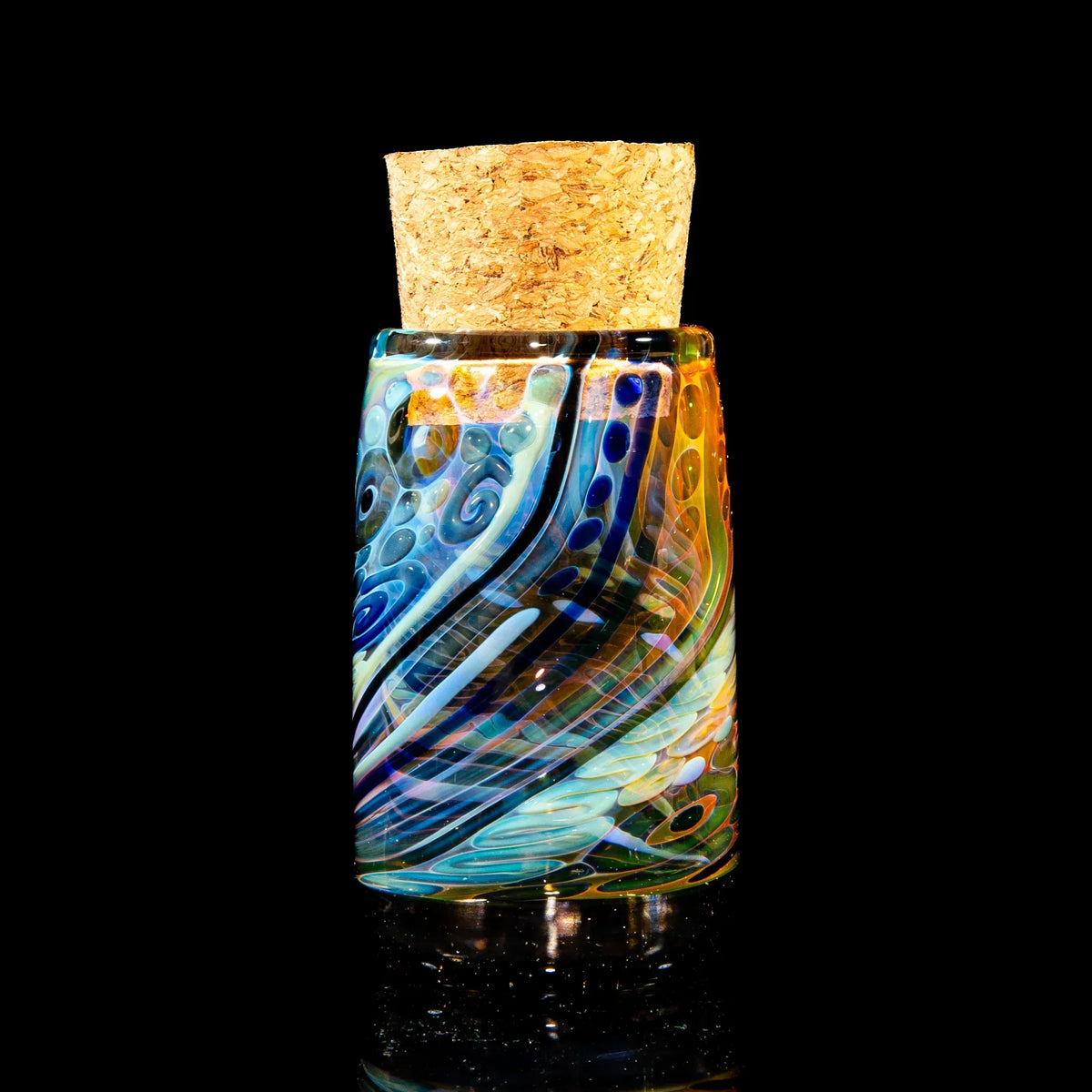 Colorful handcrafted glass jar with cork lid, featuring swirled patterns on black background.