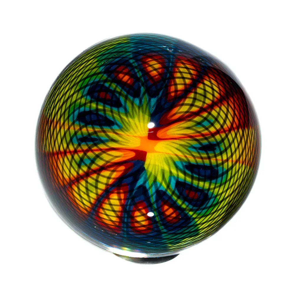 Handcrafted rainbow glass marble with vibrant black reticello pattern on white background
