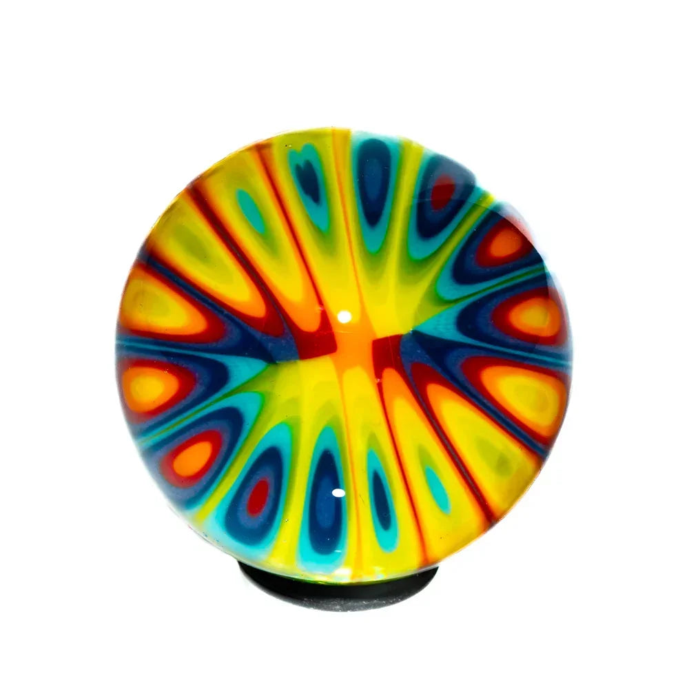 Handcrafted glass marble with vibrant rainbow millefiori pattern on a white background