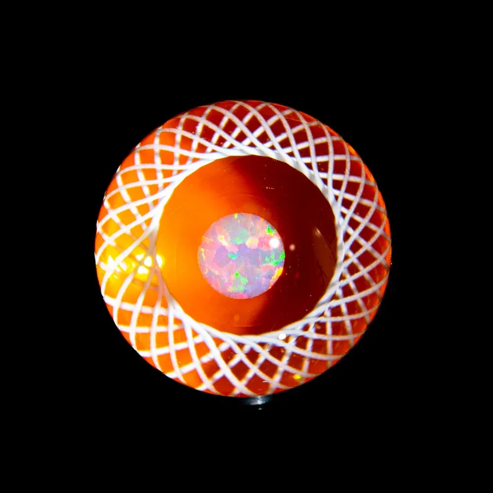 Handcrafted glass marble with orange and white lattice design and iridescent opal center