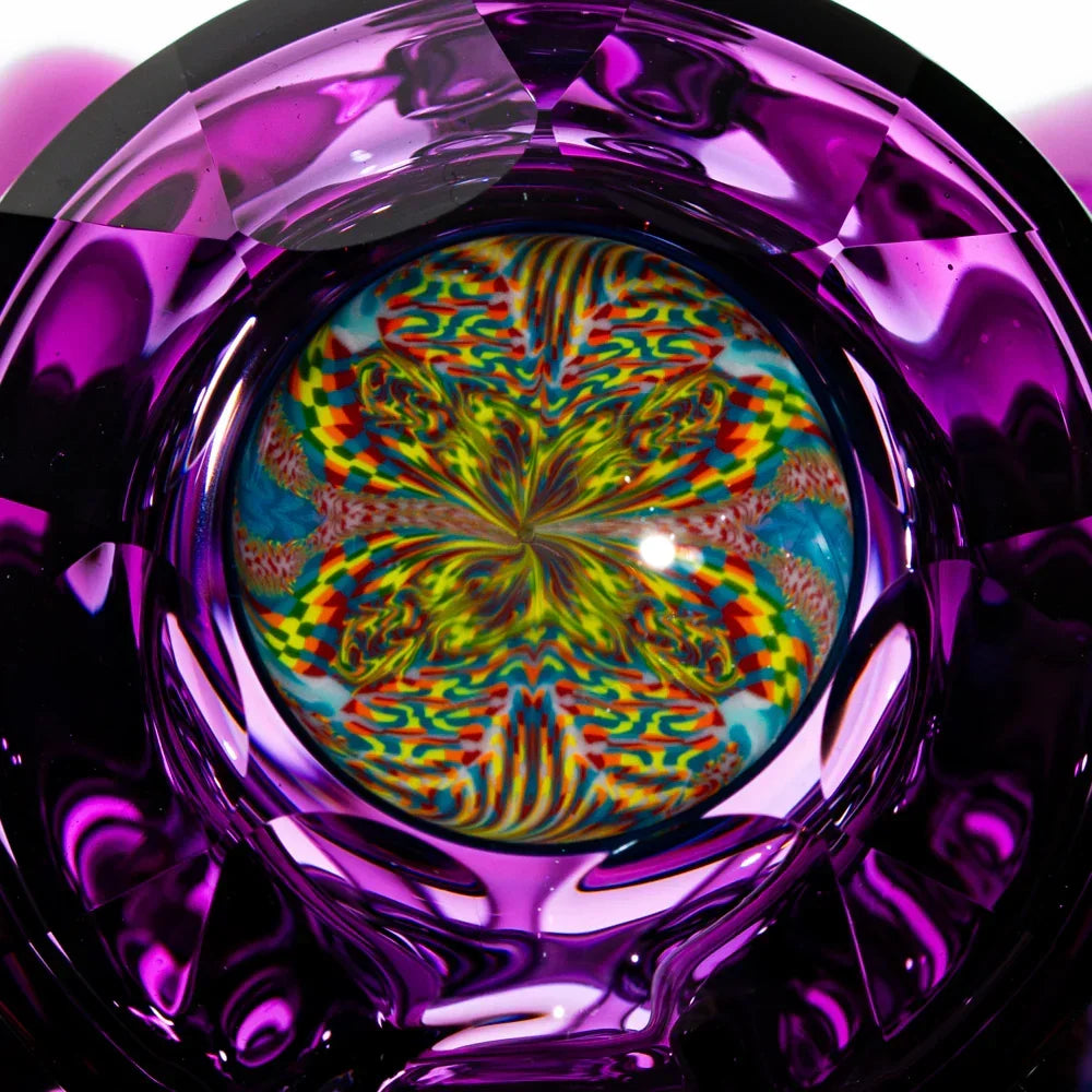 Close-up of vibrant psychedelic glass art with multicolor mandala pattern and purple accents