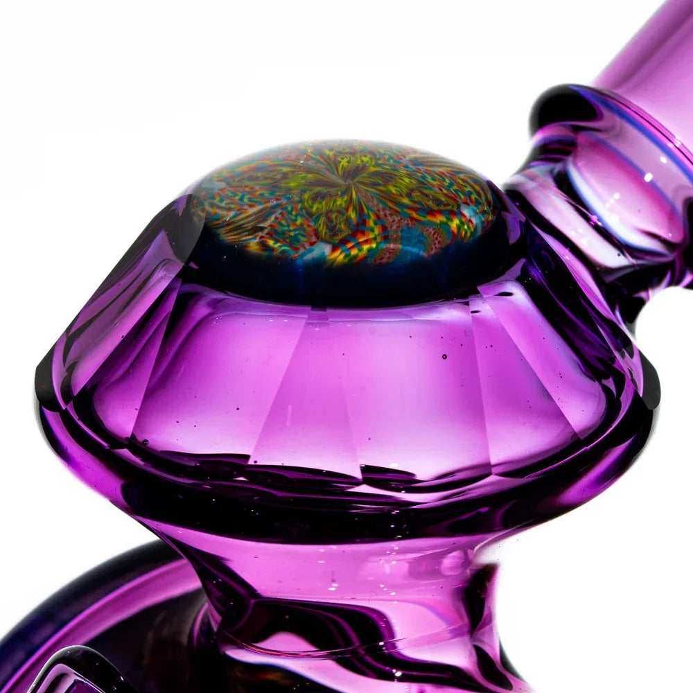 Close-up of a purple heady glass water pipe with intricate colorful marble accent