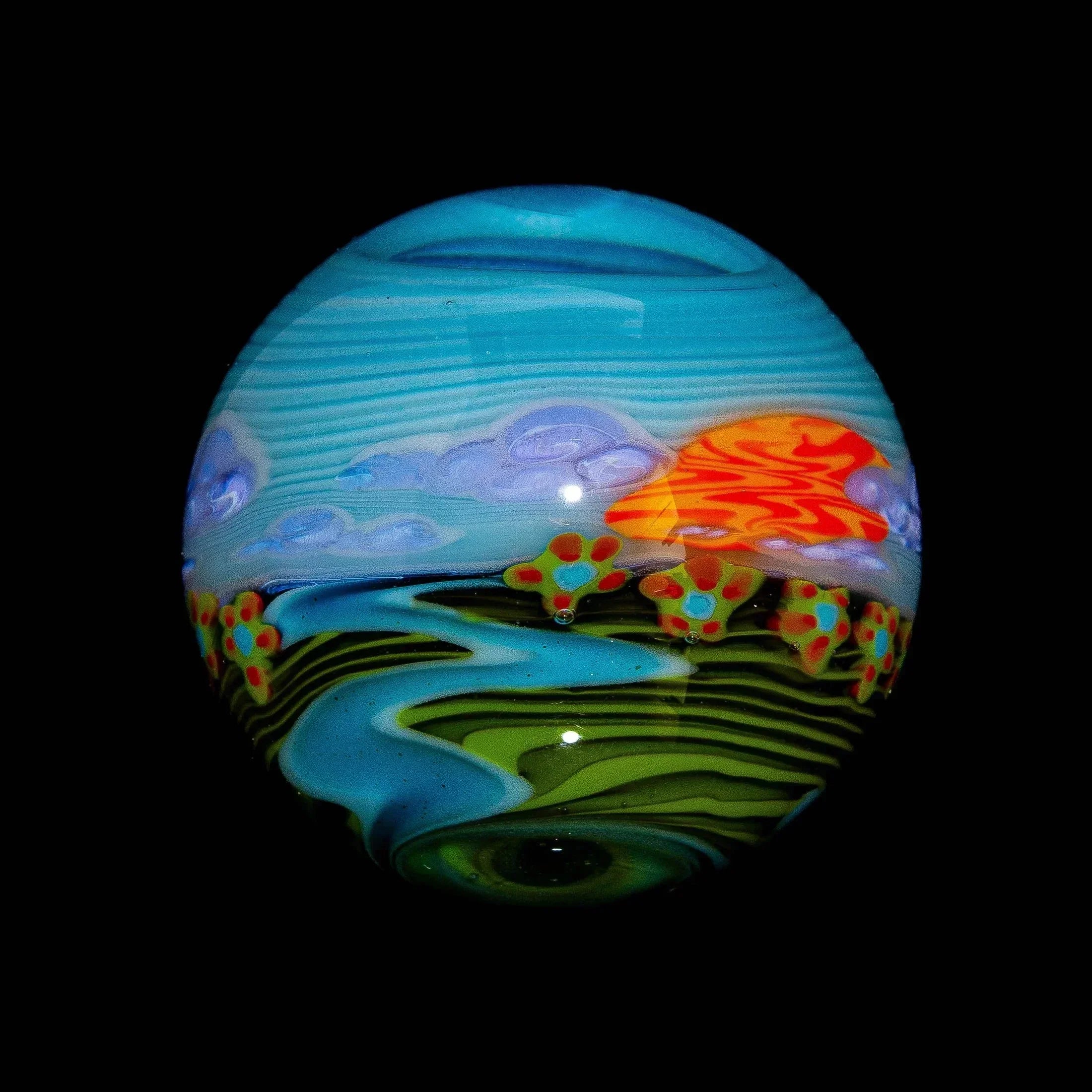 Colorful glass marble with abstract landscape, river, sunset, and flower details on black background