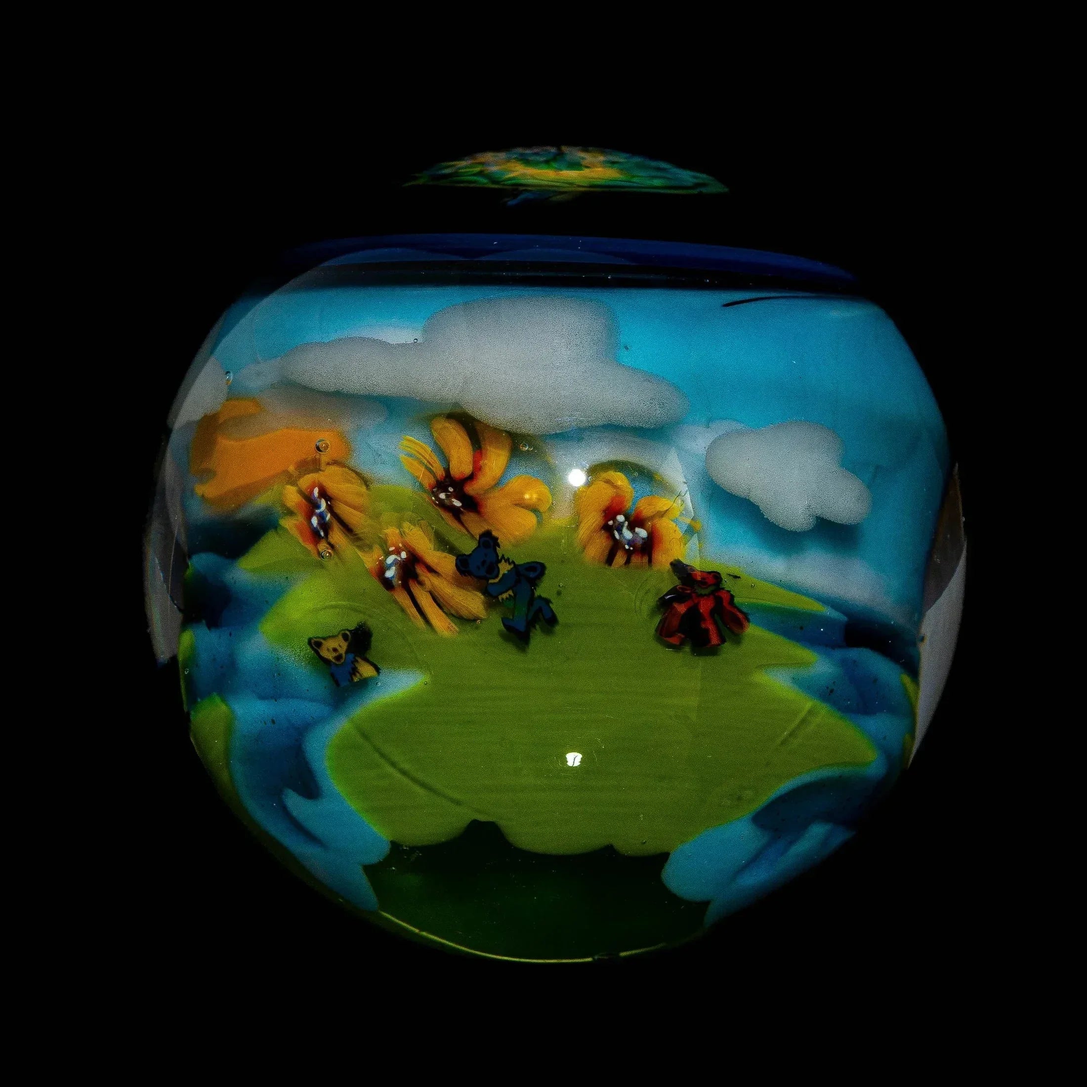 Handcrafted glass piece with colorful dancing bears, flowers, clouds, and a landscape scene
