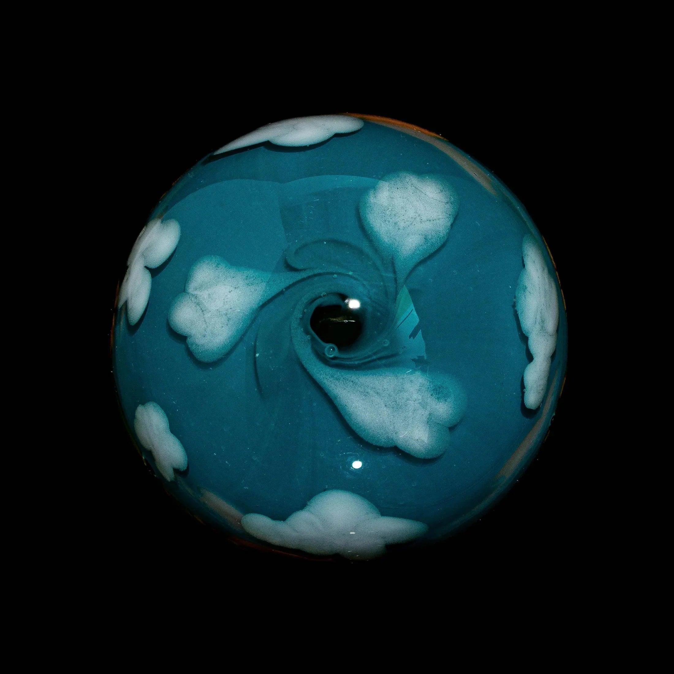 Hand-blown glass marble with blue sky and white cloud design on black background
