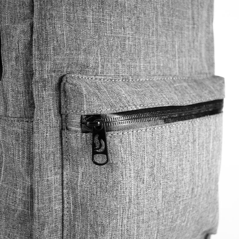 Close-up of gray fabric backpack front pocket with black zipper