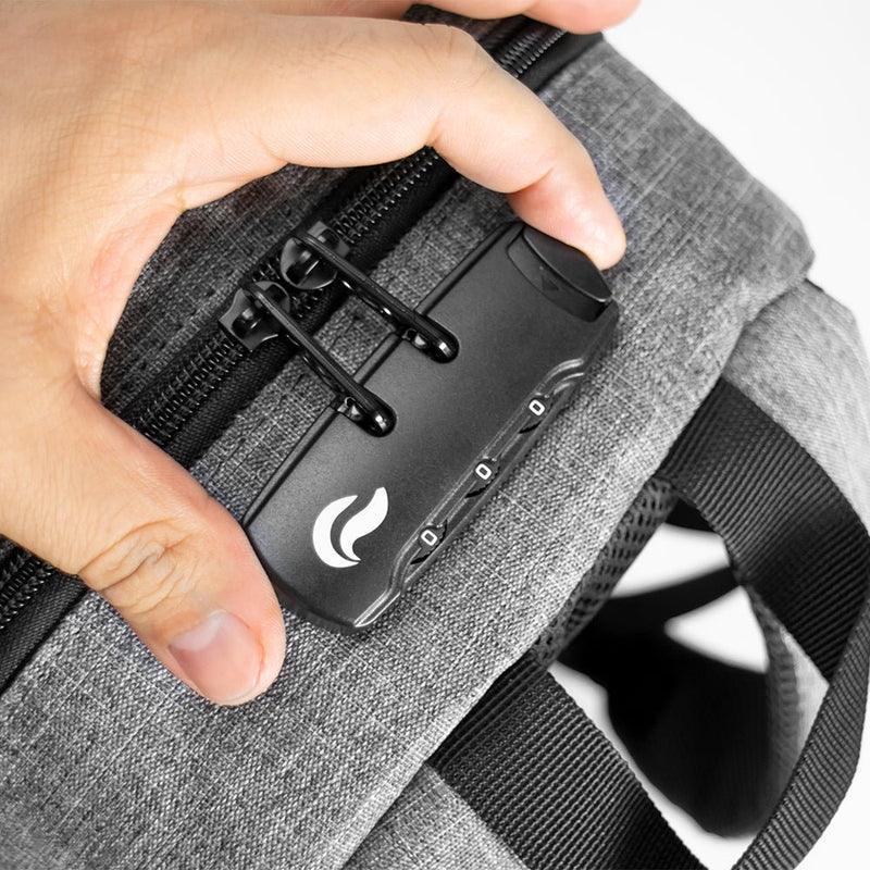 Close-up of a hand setting a combination lock on a gray smell-proof bag with black zipper pulls.