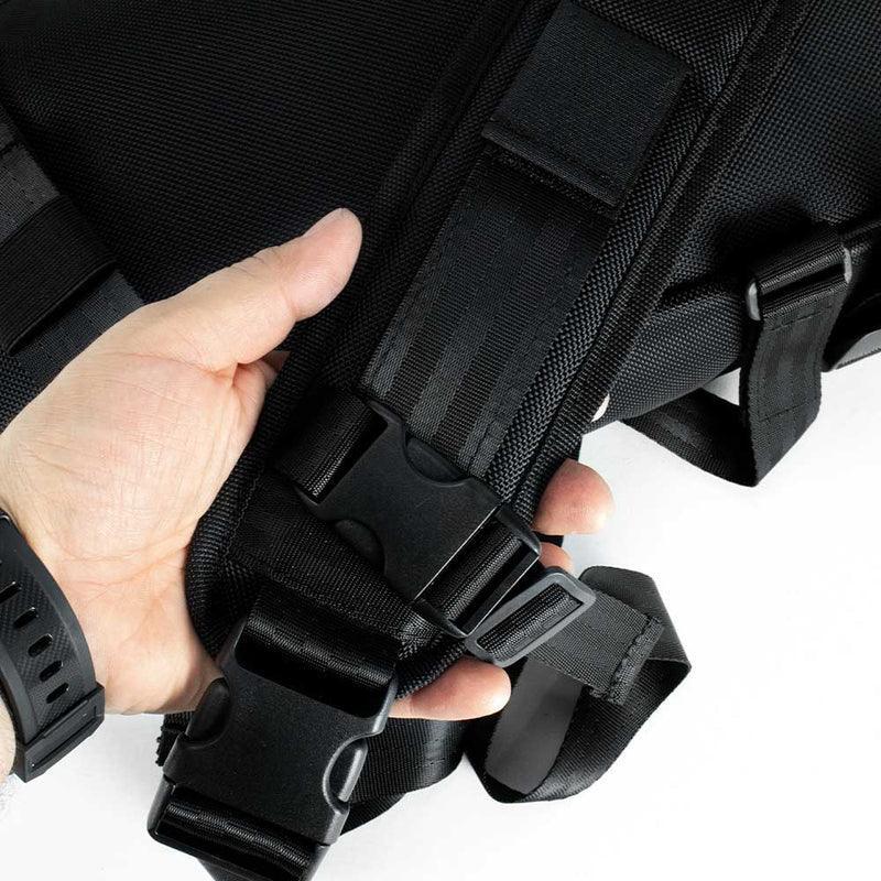 Close-up of a hand holding a black sling bag strap with adjustable buckles