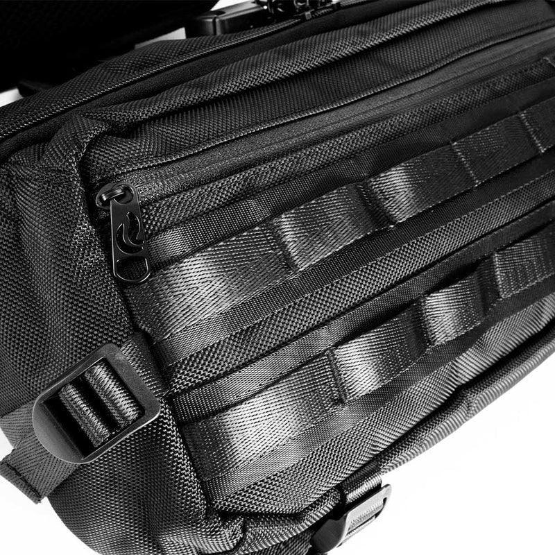 Close-up of a black tactical sling bag with durable straps and zipper details