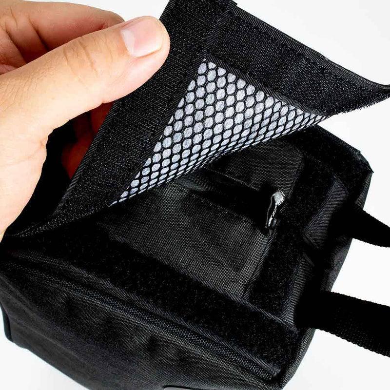 Close-up of a black travel pack with mesh-lined interior and secure Velcro closure