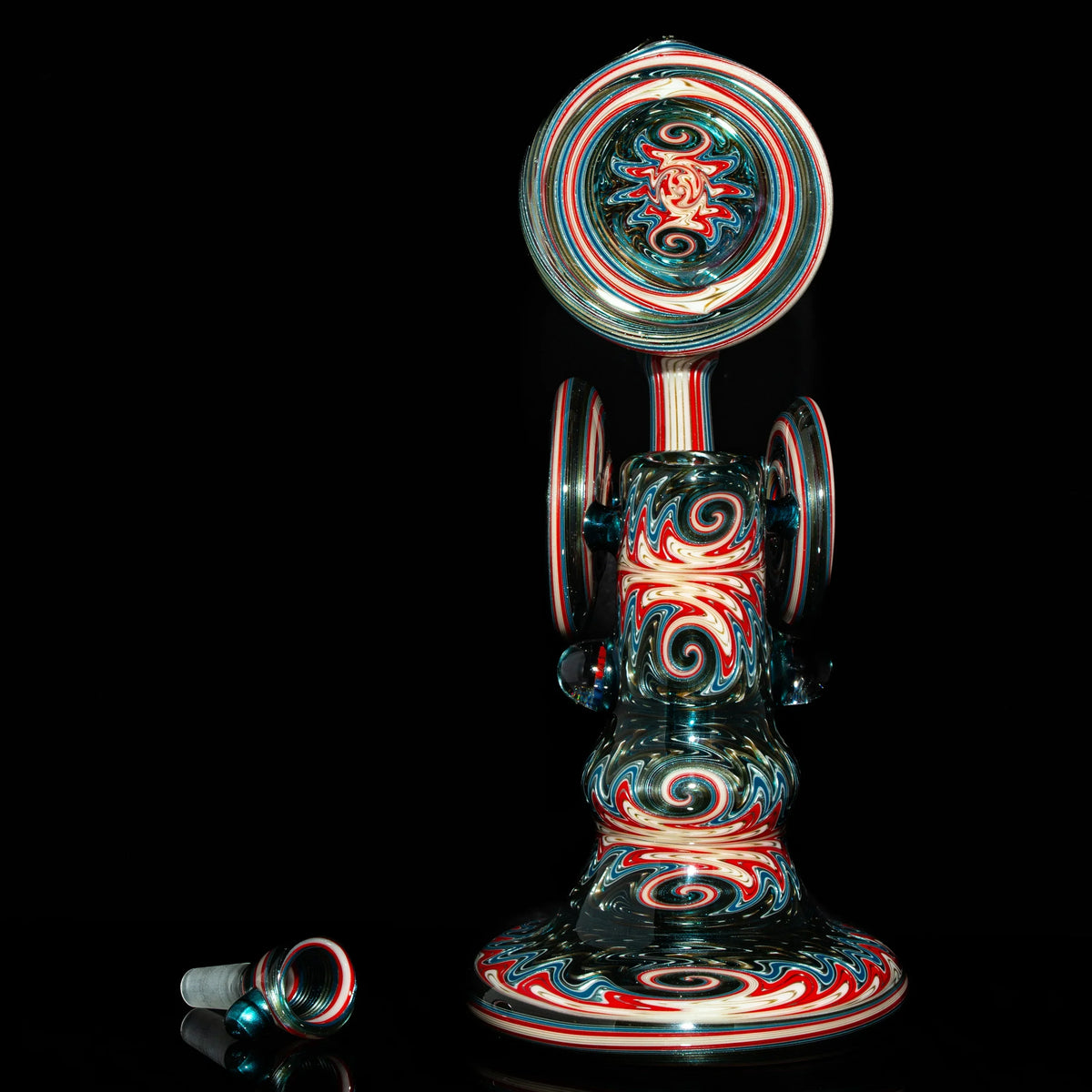 Heady glass water pipe with vibrant red, blue, and white swirl patterns on a black background
