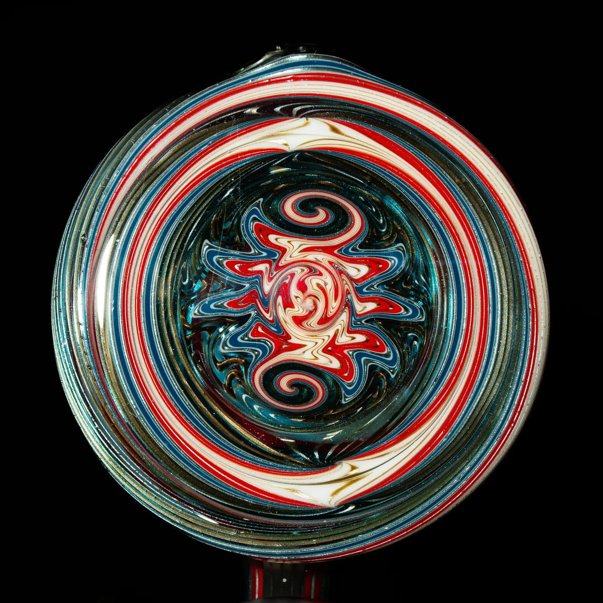 Close-up of colorful heady glass art with red, blue, and white spiral patterns