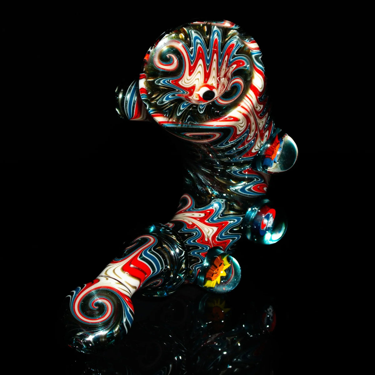 Colorful hand-blown glass pipe with red, blue, and white swirls on a black background