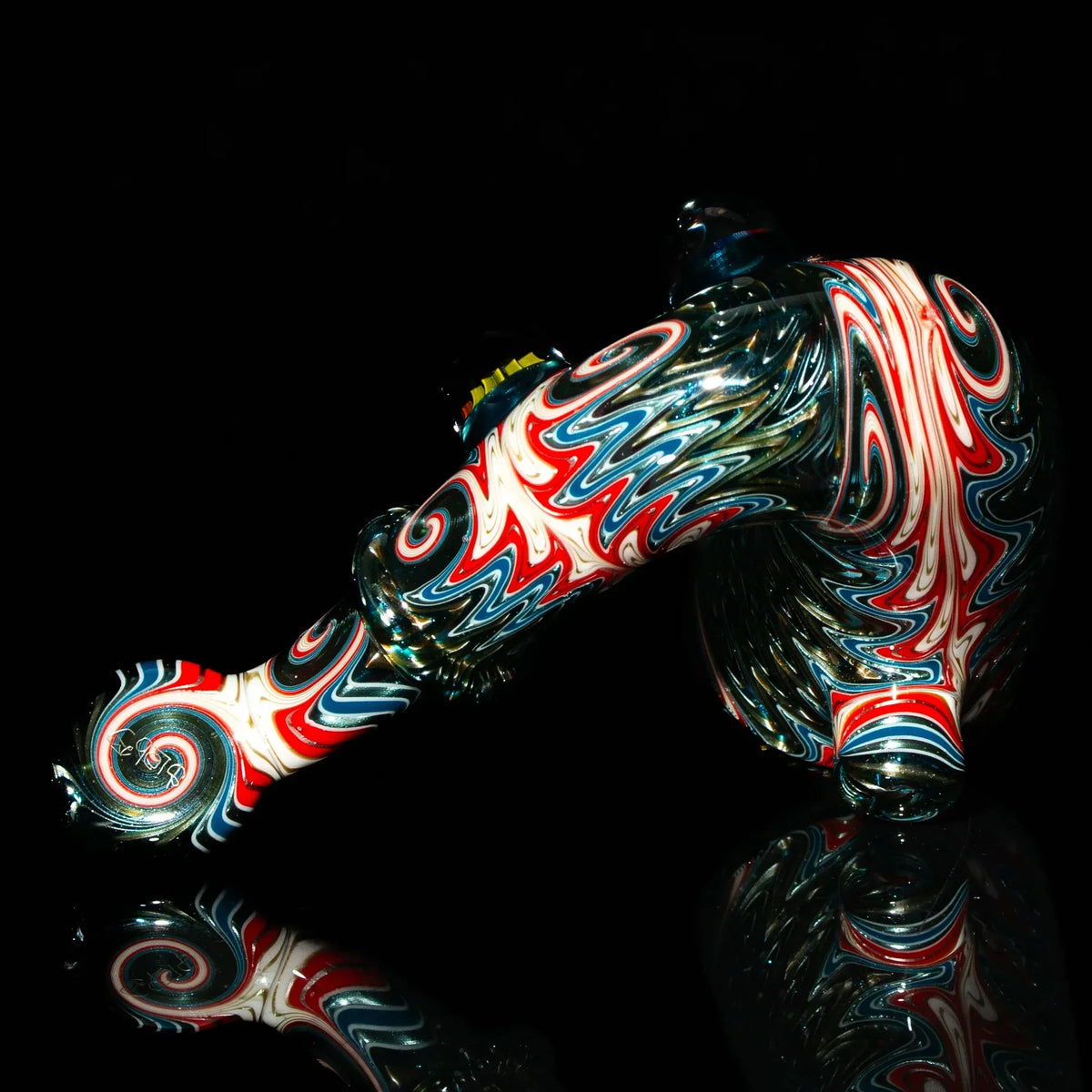 Heady glass pipe with red, white, and blue swirl patterns on a black reflective surface