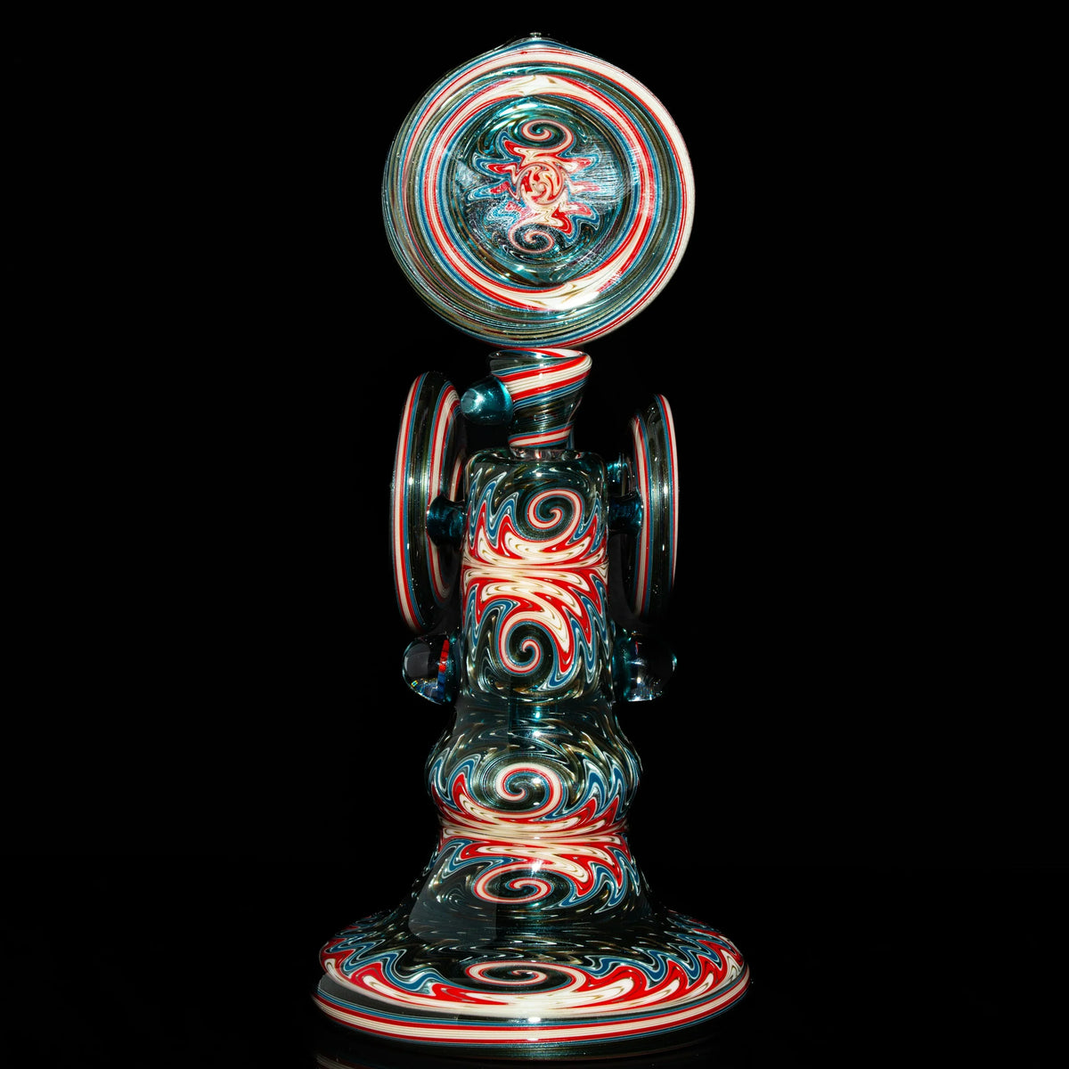 Heady glass water pipe with intricate red, white, and blue swirl patterns on black background
