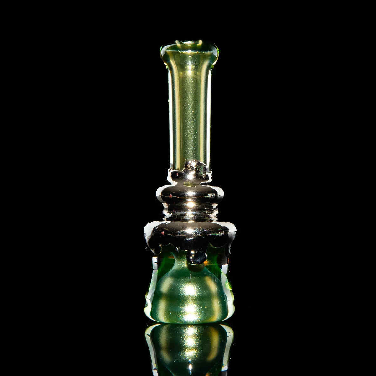 Green glass and nickel chillum with metallic accents on a reflective black background