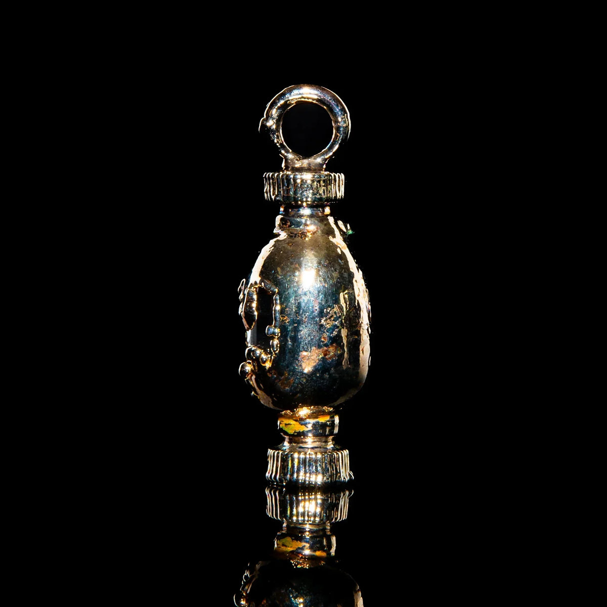Handcrafted silver pendant with textured details on a black background