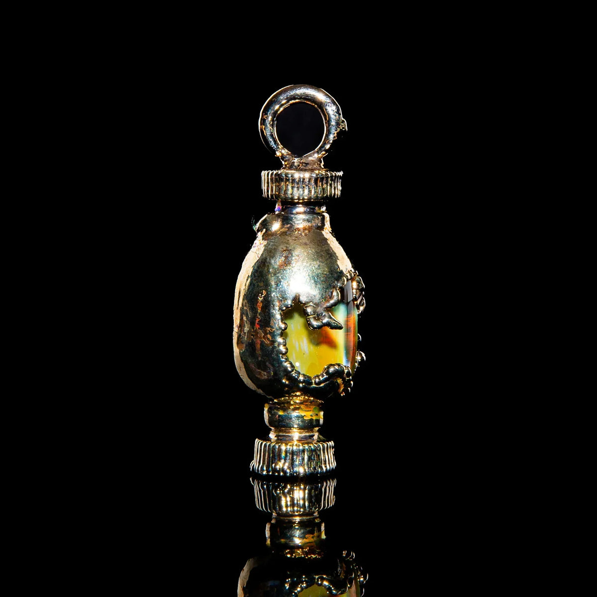 Handcrafted silver pendant with glass accent and metallic details on black background
