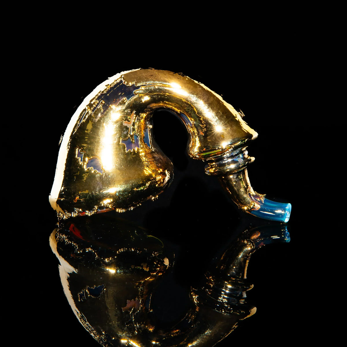Gold sherlock glass pipe with blue mouthpiece on black reflective surface
