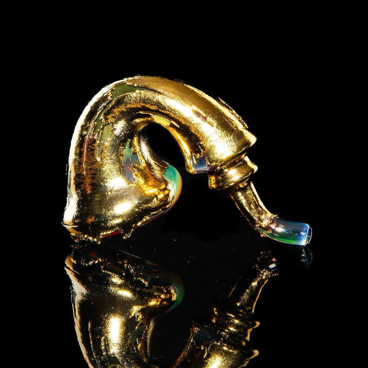 Gold sherlock glass pipe with iridescent mouthpiece on black reflective surface