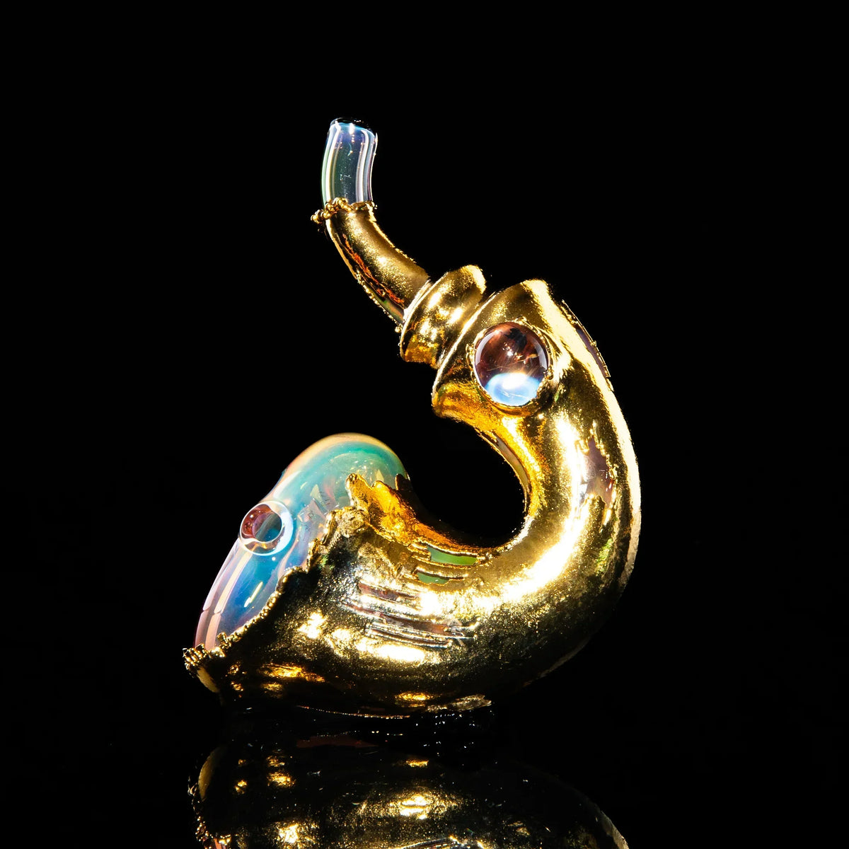 Gold sherlock hand pipe with iridescent glass accents on a black background