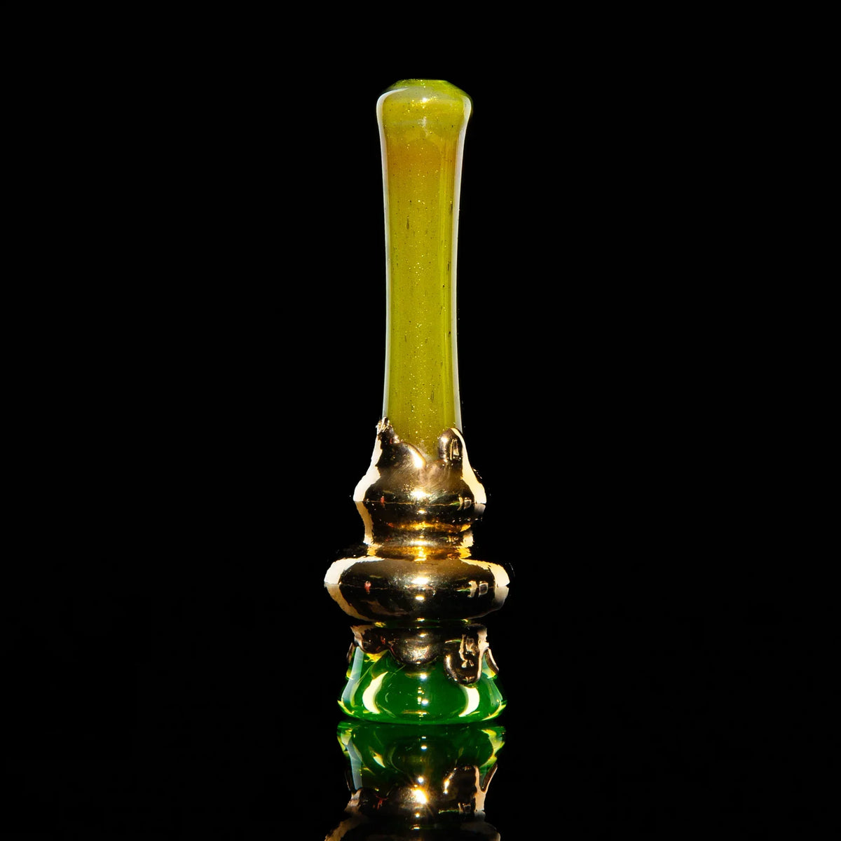 Gold and green glass chillum pipe with metallic finish on a black background