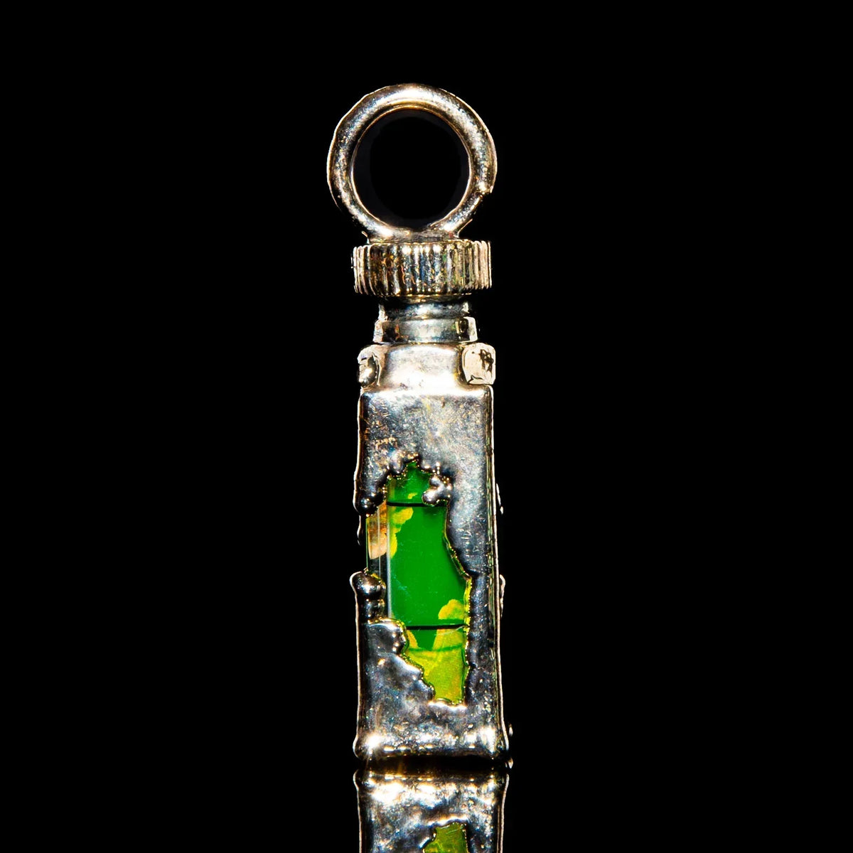 Silver pendant with green glass accent, unique handcrafted jewelry on black background.
