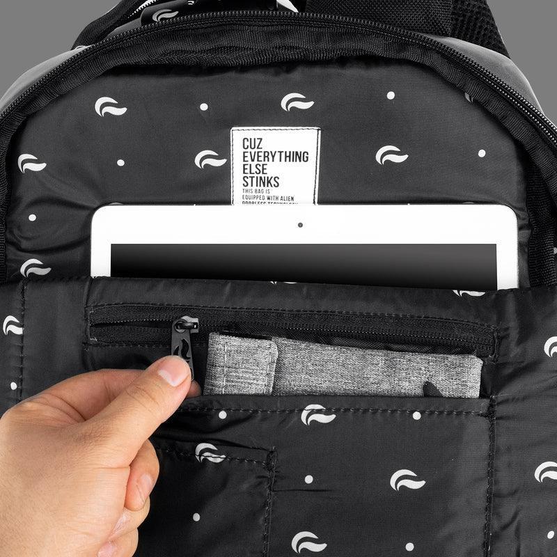 Black patterned backpack interior with tablet pocket, zip pouch, and organizer compartments.