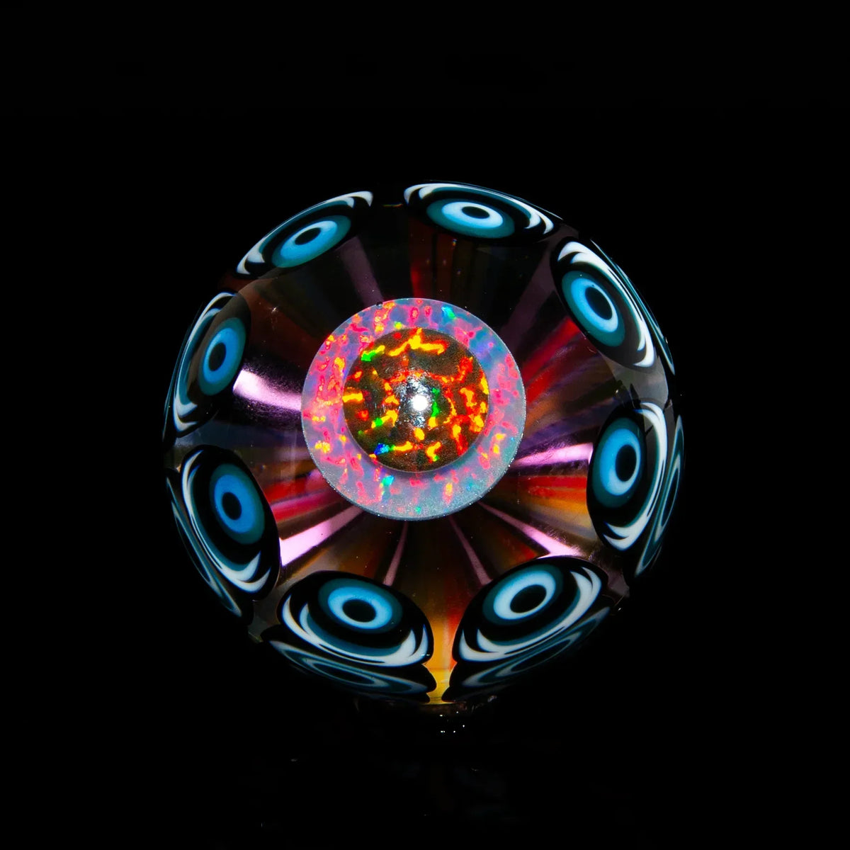 Colorful glass marble with intricate blue eye pattern and vibrant center design on black background