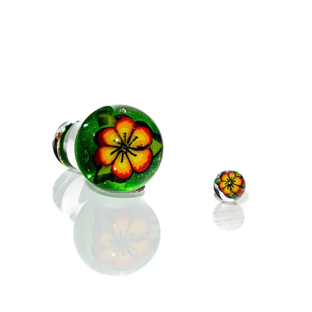 Handmade glass cap with vibrant green base and yellow-red hibiscus flower design