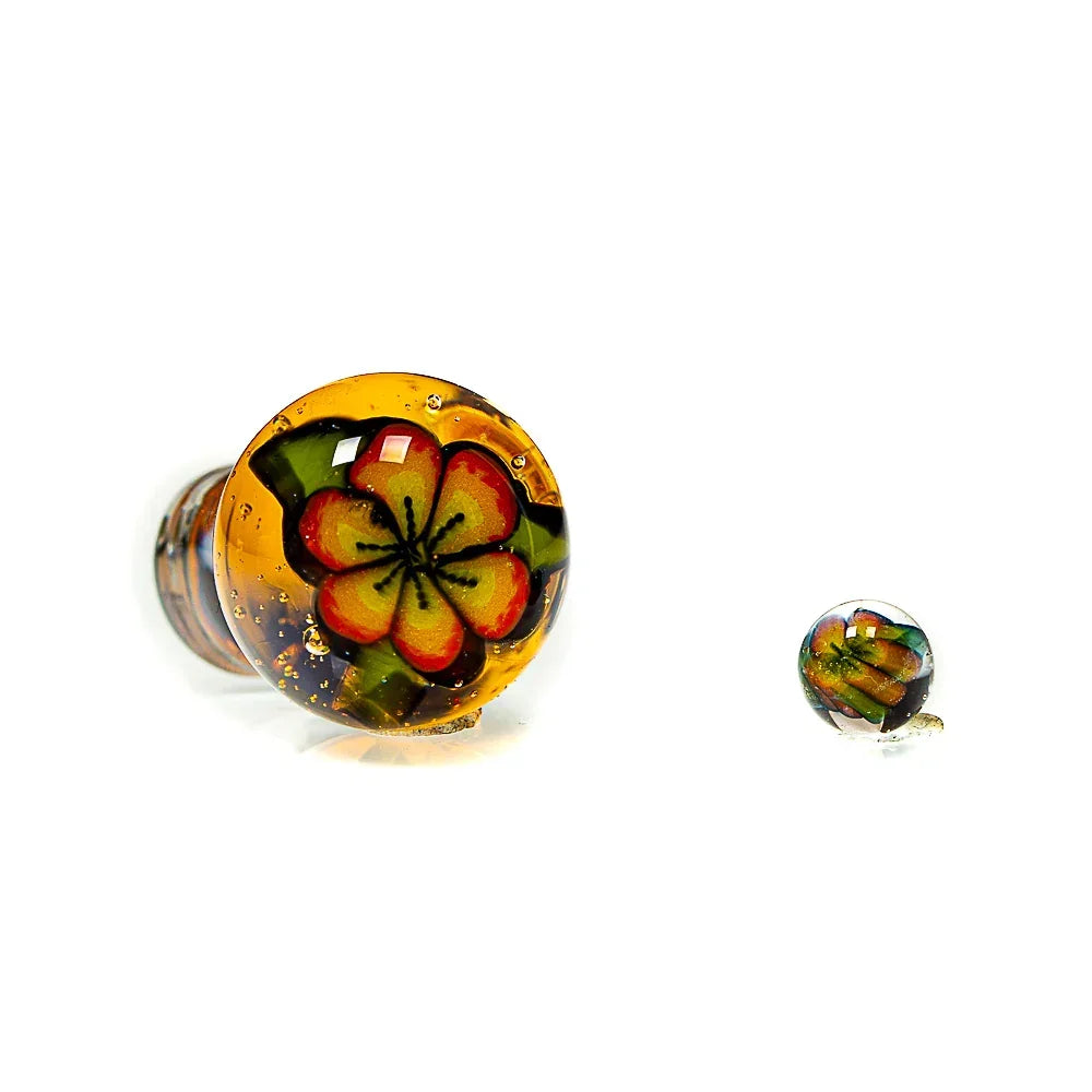 Handcrafted glass carb cap with yellow and red hibiscus flower design on white background