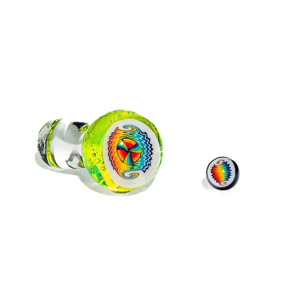 Handmade glass carb cap with vibrant rainbow wigwag design and green accents on white background