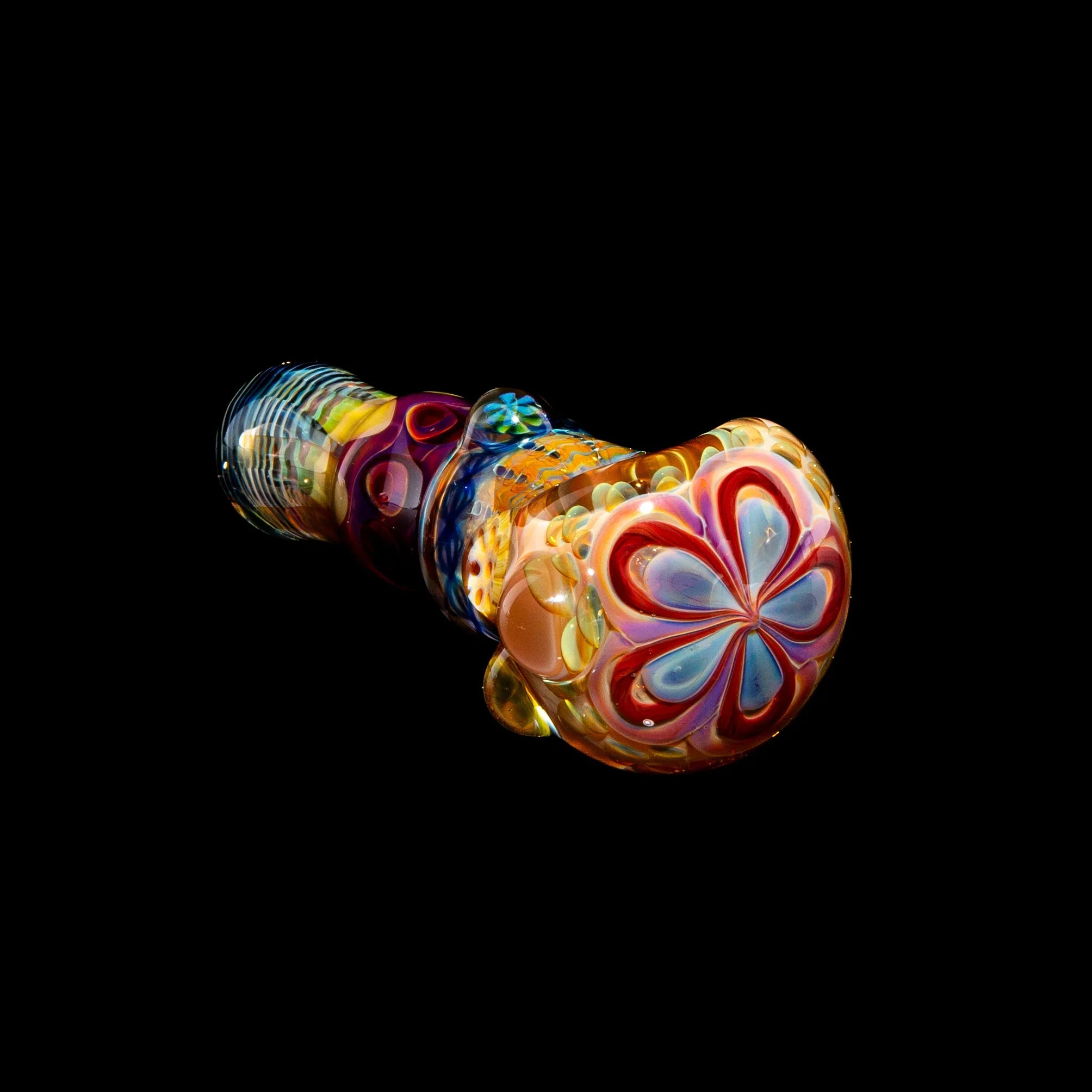 Colorful glass spoon pipe with flower and ribbon patterns against a black background