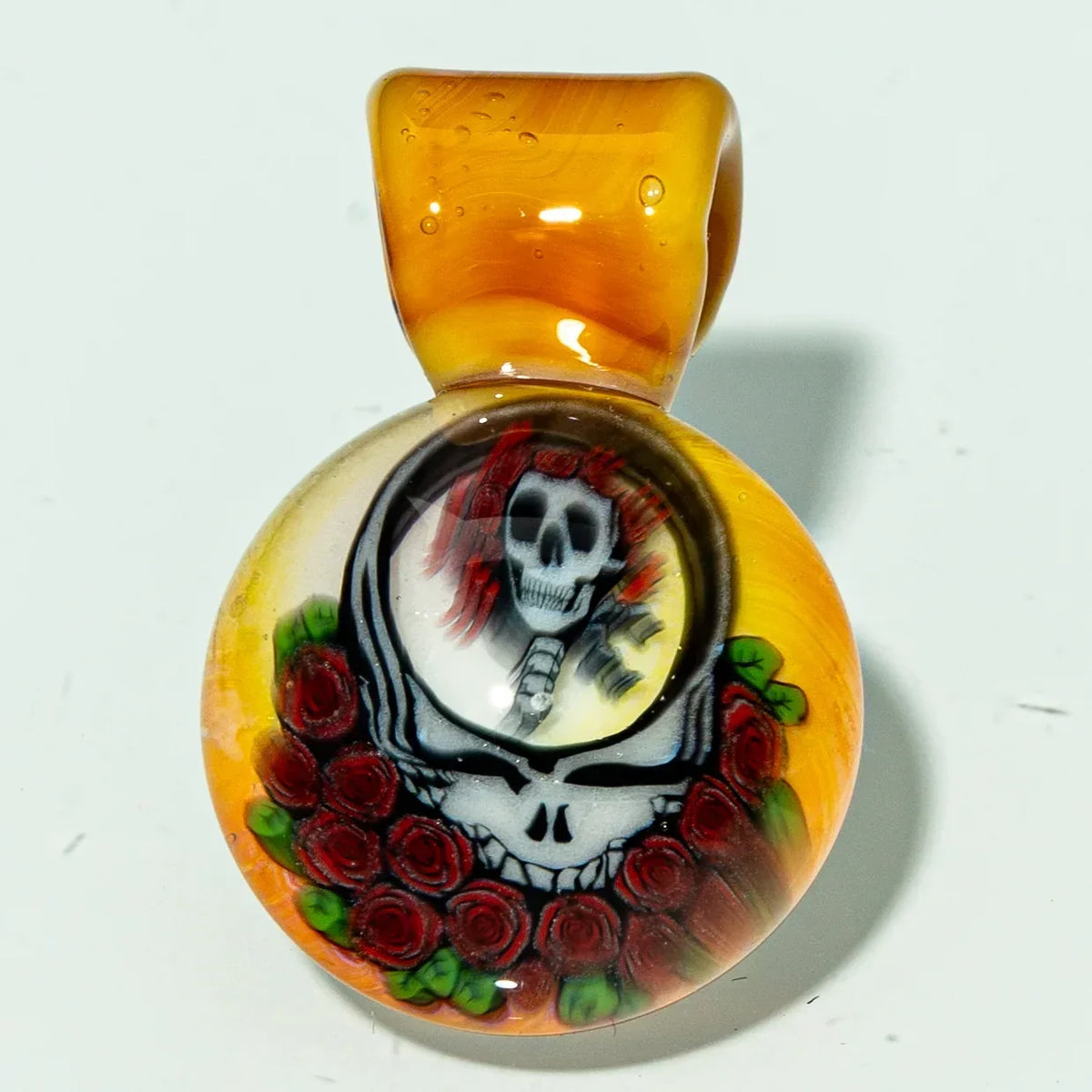 Hand-blown glass pendant with skull and roses design, yellow background, smoke shop accessory