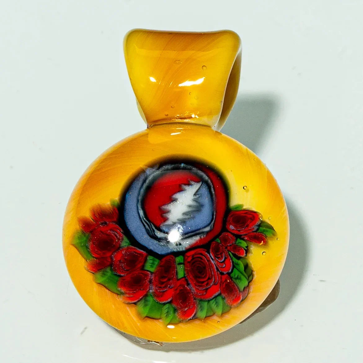 Handmade glass pendant with red roses and lightning bolt design on a yellow background