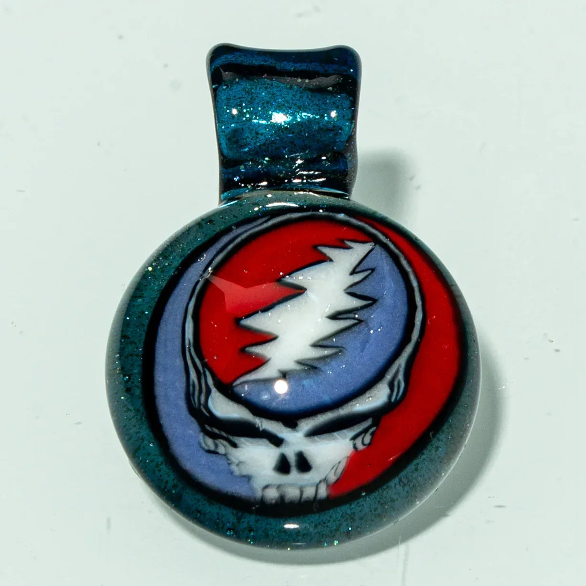 Handmade glass pendant with skull and lightning bolt design, red and blue background