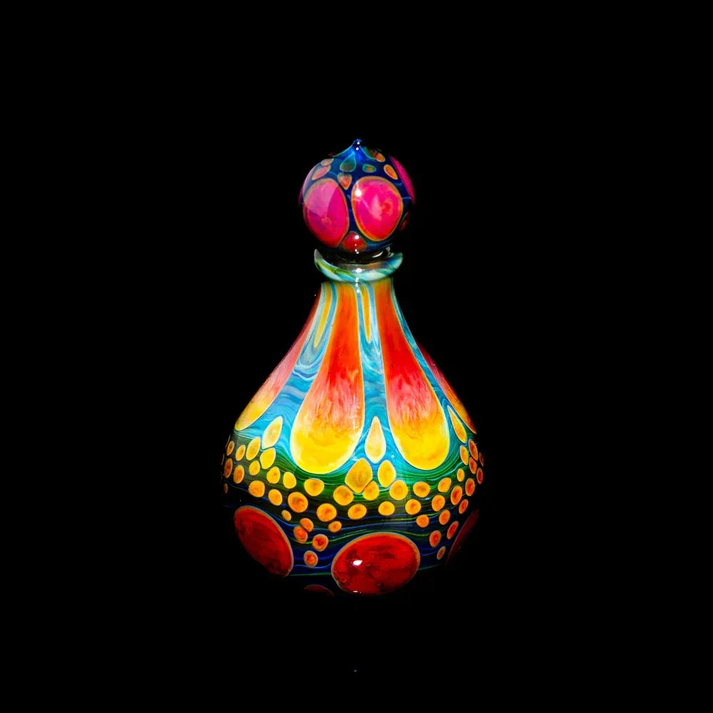 Colorful heady glass art piece with bright red, yellow, and blue patterns on black background