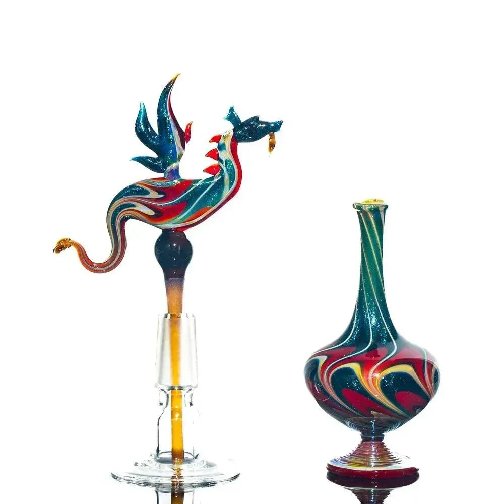 Colorful dragon-topped glass perfume jar and matching swirled glass vessel on white background.