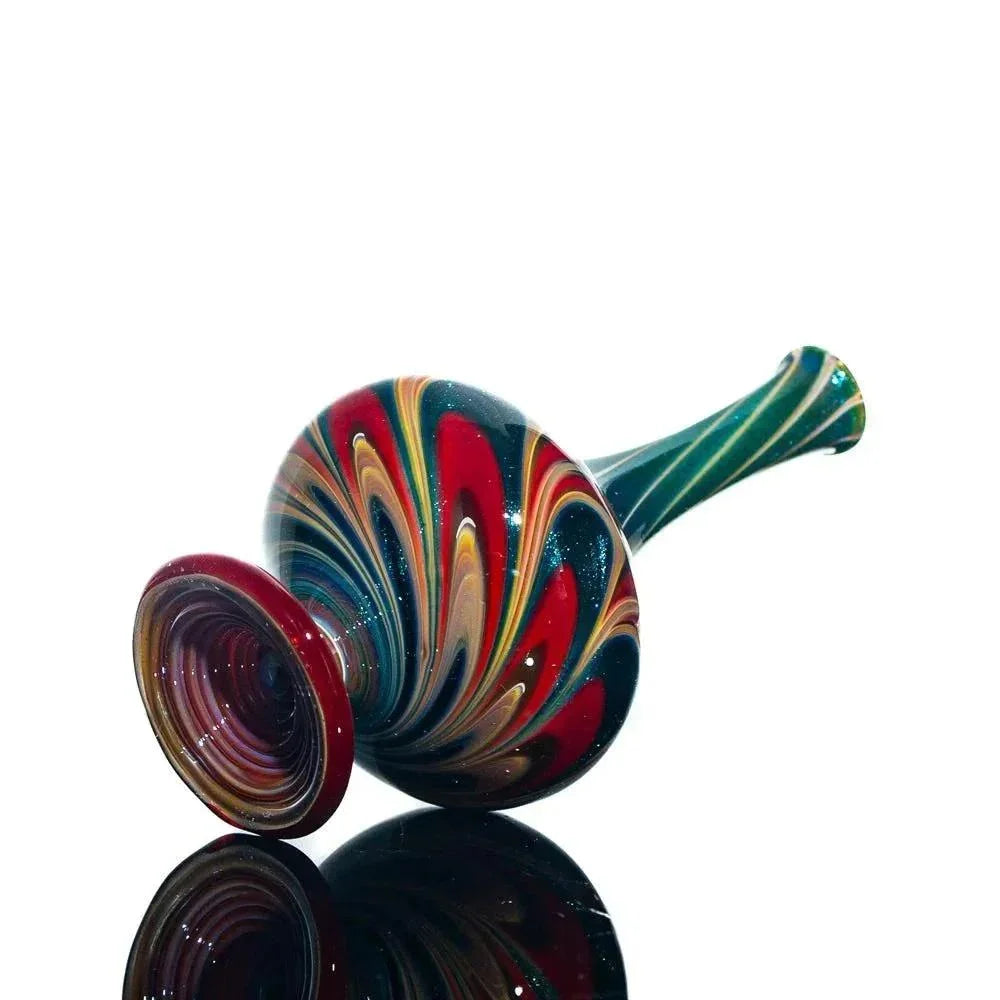 Handblown glass perfume jar with vibrant swirling multicolor pattern on white background
