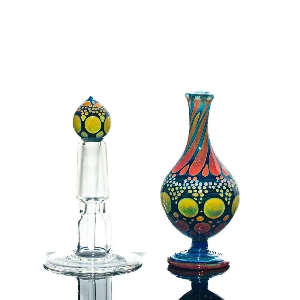 Colorful hand-blown glass perfume jar with stopper, featuring vibrant dot patterns.