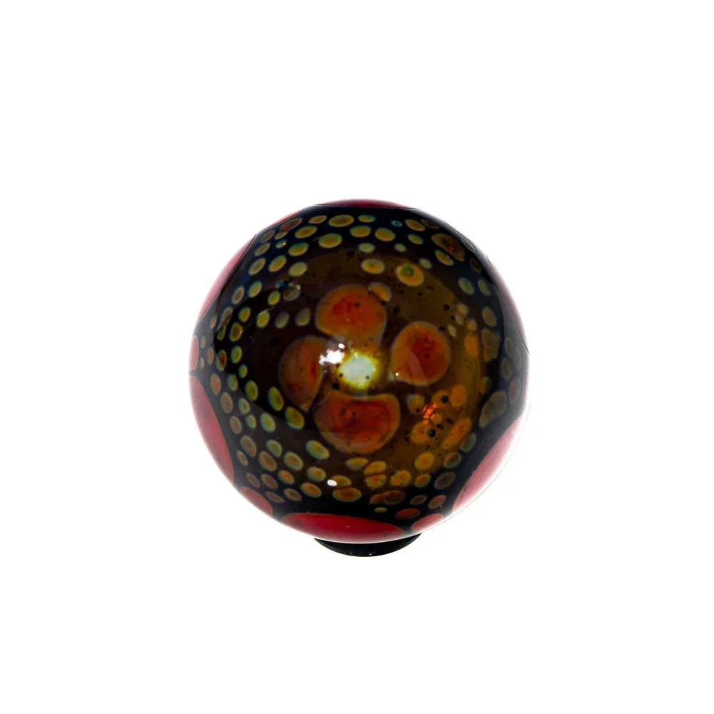 Hand-blown glass marble with colorful floral and dotted design on white background