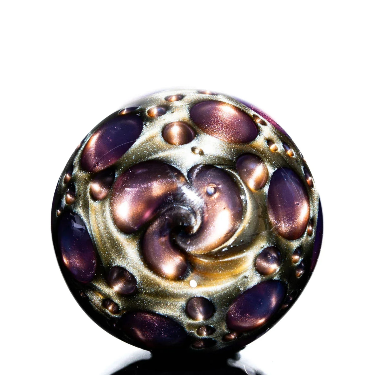 Hand-blown glass marble with purple and gold swirl patterns and raised bubble accents
