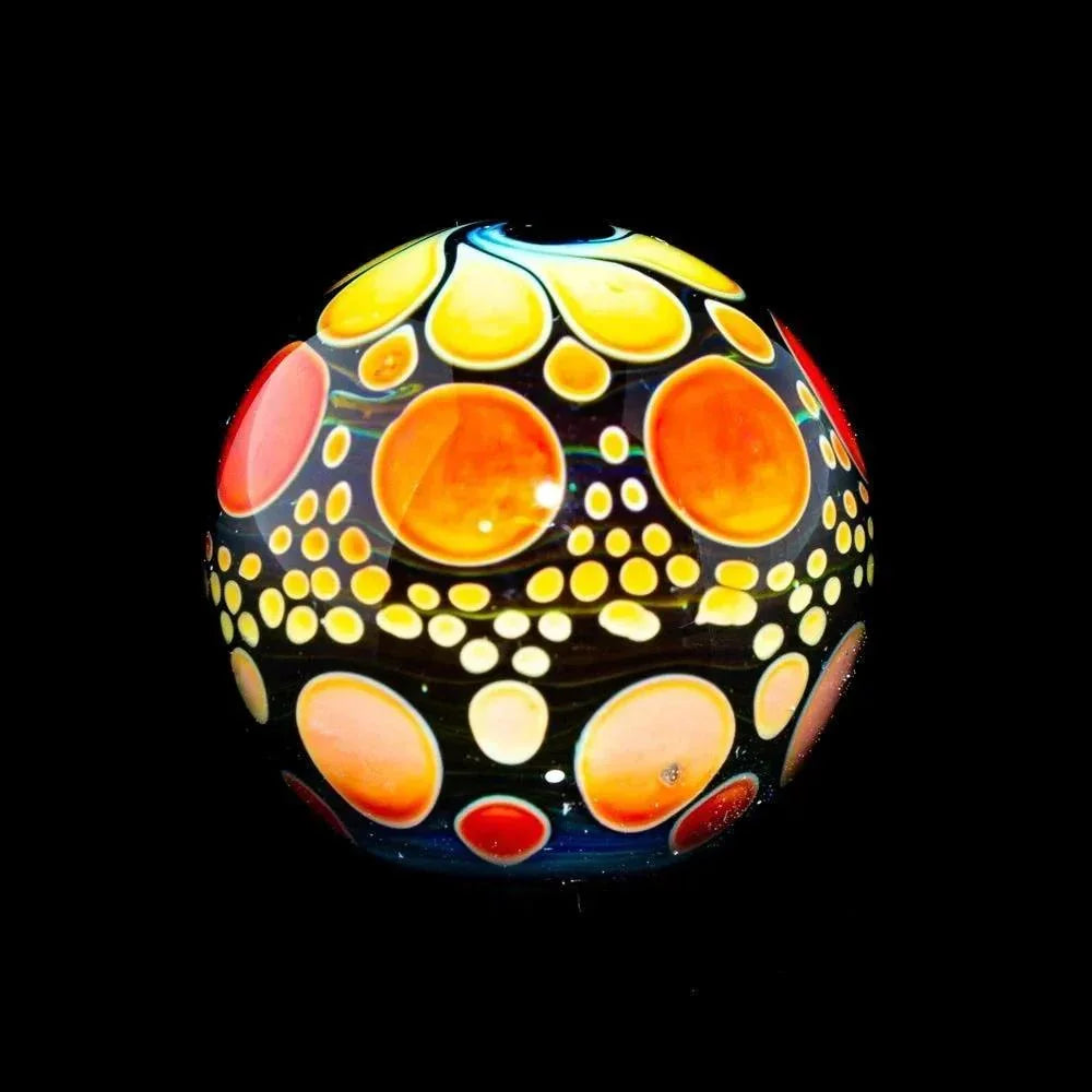 Handcrafted orange ombre hobnail glass marble with vibrant bubble pattern on black background.