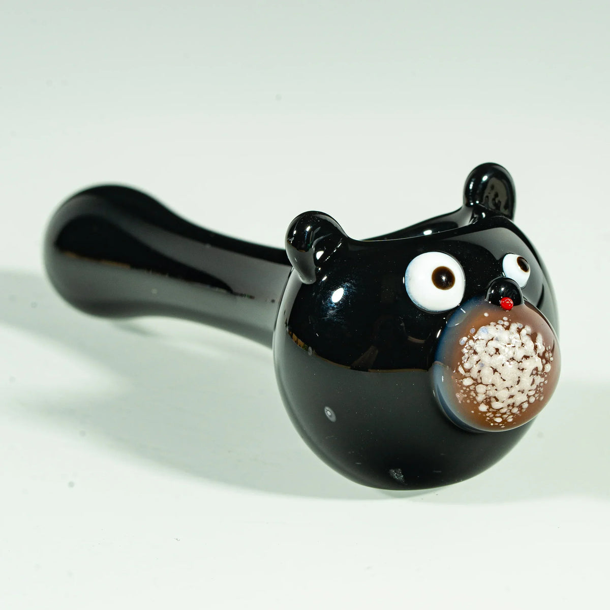 Black glass hand pipe shaped like a bear with detailed face, used for smoking.