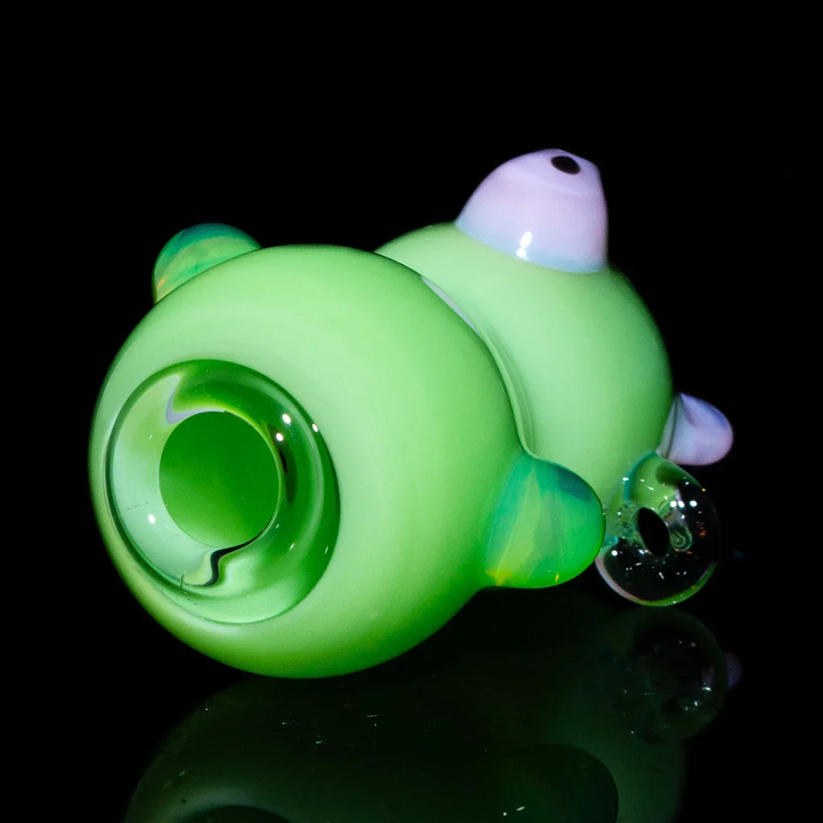 Green glass bear-shaped joint holder with clear accents on a black background