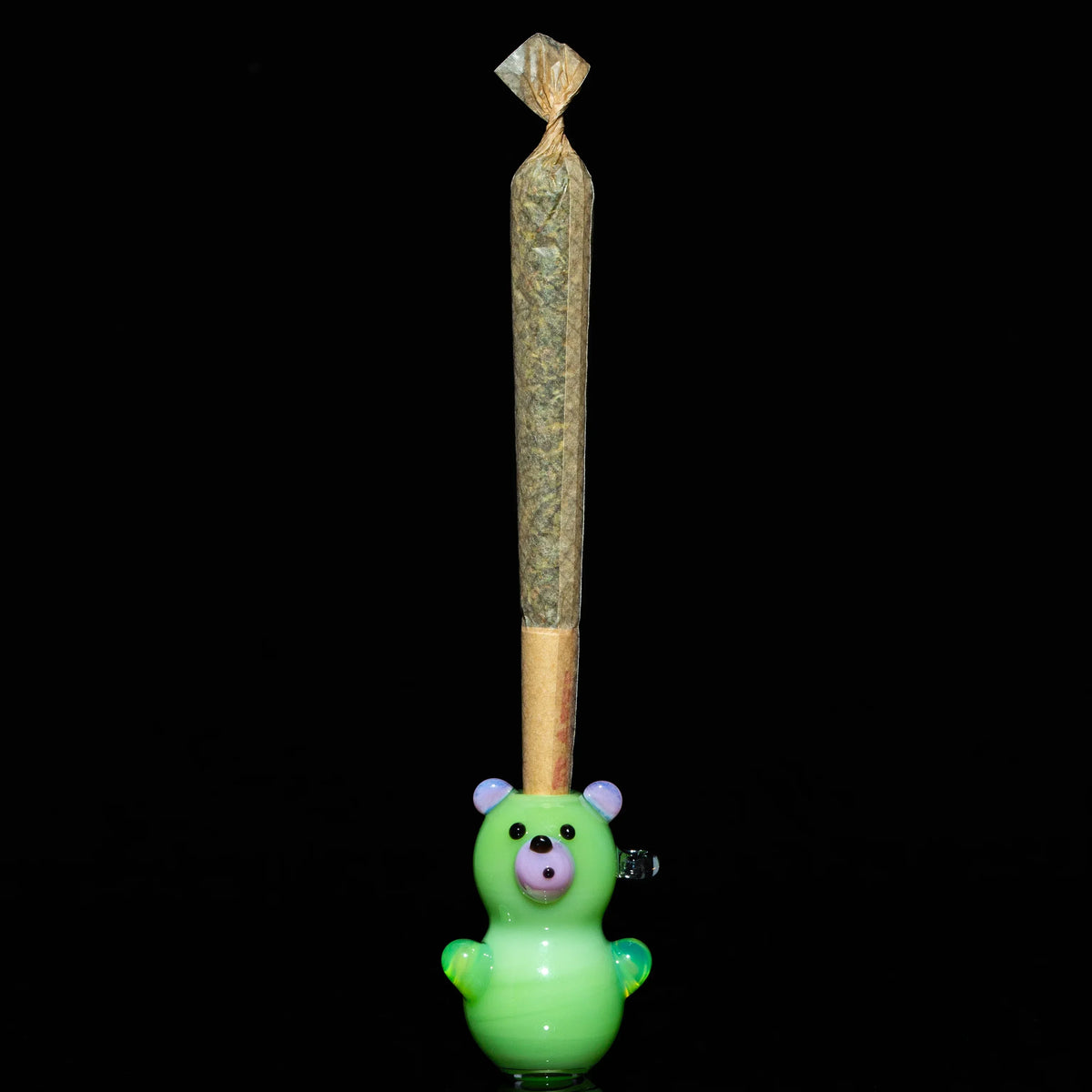 Green bear glass joint holder with a pre-rolled cone on black background