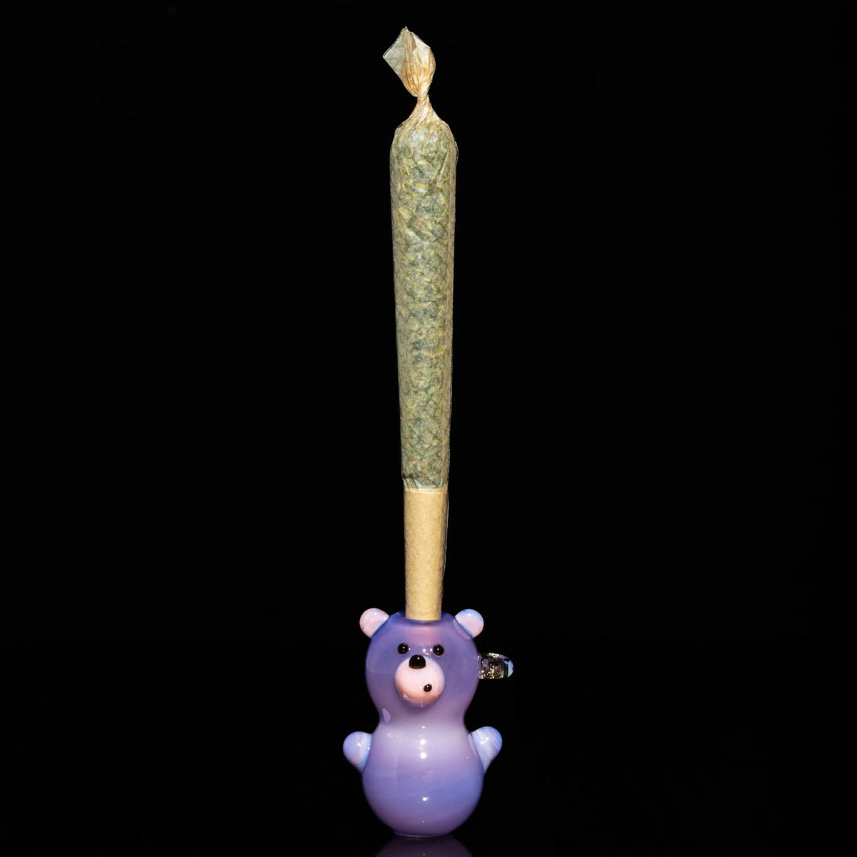 Purple glass bear joint holder with pre-rolled cone on black background