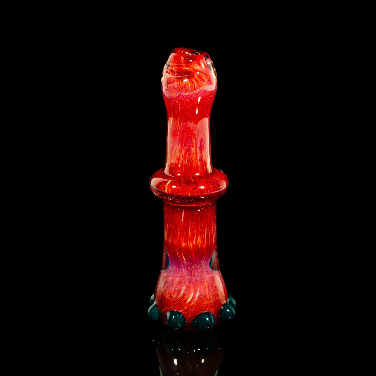 Handcrafted red glass smoking accessory with blue accents on black background